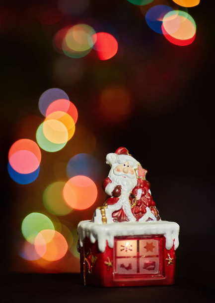Joulupukki patsas tekee harjoituksen odottaa joulua. Värillinen bokeh - Valokuva, kuva