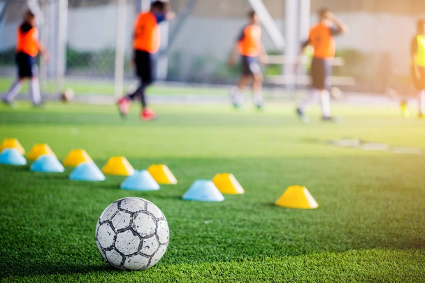 Футбол на зеленому штучному газоні з розмитими конусами і футболістами тренується. Футбольна академія
. - Фото, зображення
