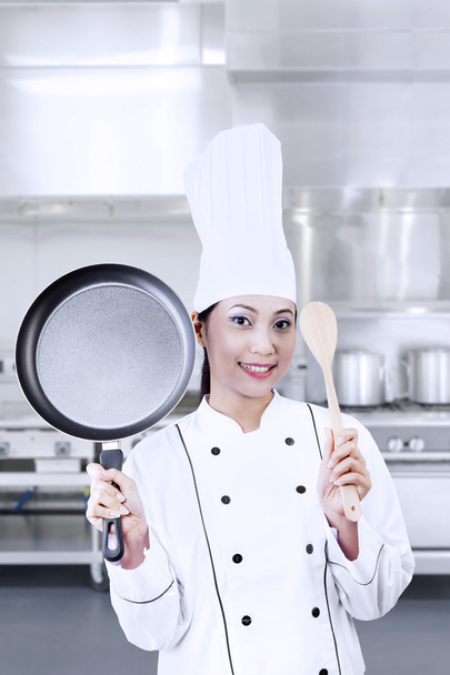 Chef holding pan and wooden spoon - Photo, image
