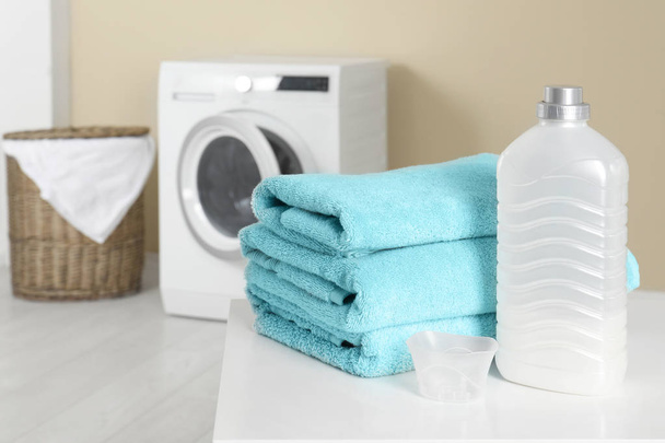 Stack of clean towels and detergent on table in laundry room. space for text - Zdjęcie, obraz