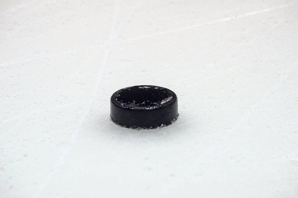 black hockey puck on ice rink. Winter sport. - Photo, Image