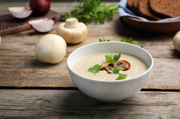 Bowl of fresh homemade mushroom soup on wooden table - Foto, afbeelding