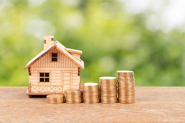 Modèle de maison et pile de pièces sur fond d'arbre vert concept d'économie hypothécaire
 - Photo, image