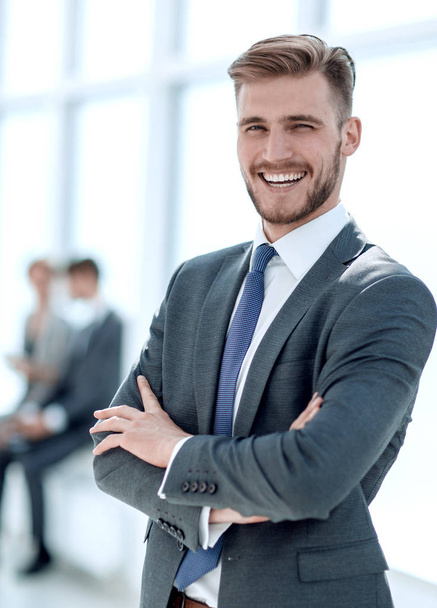 successful businessman on the background of a bright office. - Φωτογραφία, εικόνα