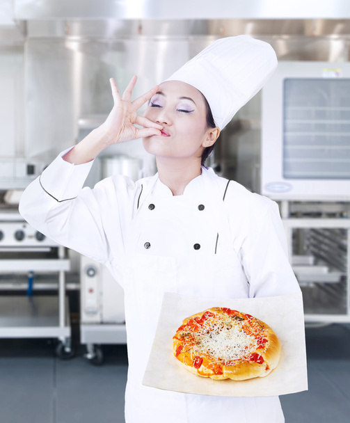 Delicious pizza hold by chef on kitchen - Φωτογραφία, εικόνα