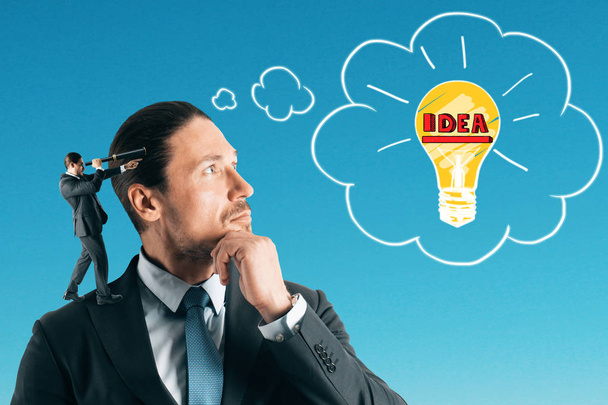 Handsome european businessman thinking about idea lamp on blue sky background. Innovation and research concept  - Photo, Image