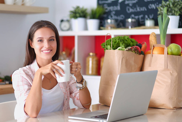 Smiling woman online shopping using tablet and credit card in kitchen . Smiling woman - Foto, Imagem