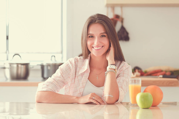 Young woman sitting a table in the kitchen. Young woman - Foto, imagen