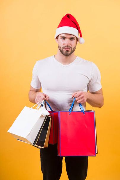 The morning before Xmas. man in santa hat hold christmas present. delivery christmas gifts. happy santa man on yellow background. online christmas shopping. Happy new year. Christmas composition - Фото, изображение