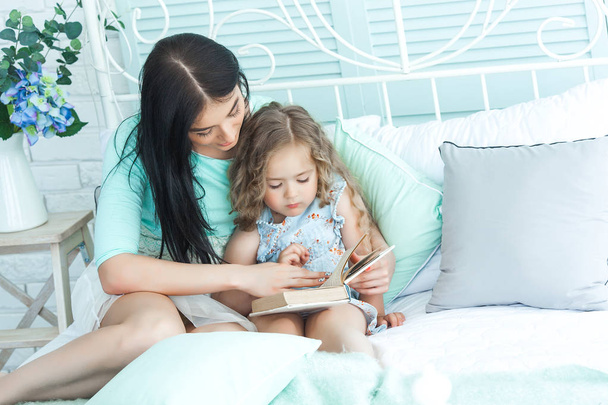 Liebevolle Mutter liest ihrem Kind eine Gute-Nacht-Geschichte vor - Foto, Bild