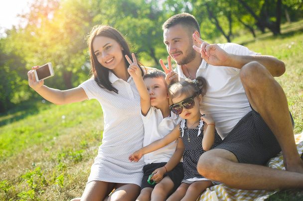 Iloinen perhe tekee selfie ulkona
 - Valokuva, kuva