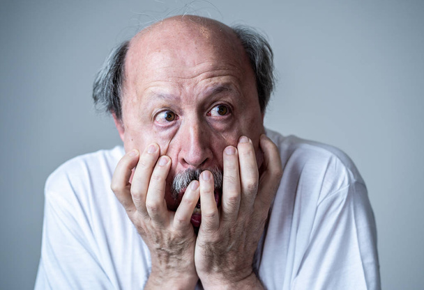 Close up portrait of a scared frightened old man in expression of fear in human emotions and facial expressions isolated in neutral background. - Fotoğraf, Görsel