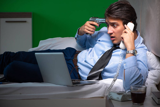 Young businessman under stress in the bedroom at night - Photo, Image