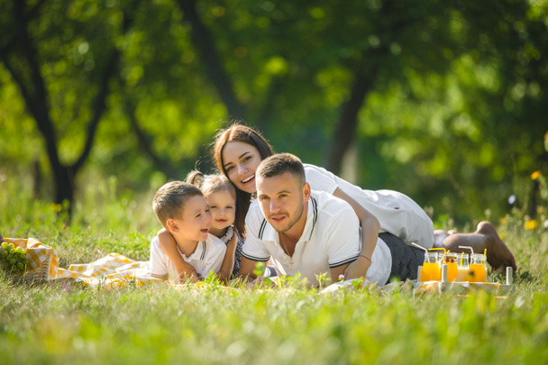 Alegre familia de picnic. Padres cenando con sus hijos al aire libre
. - Foto, Imagen
