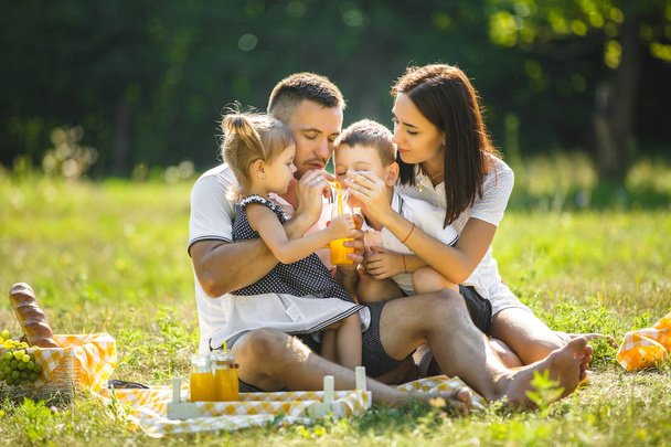 Vidám család piknik. Szülők vacsorázik a gyerekek kint. - Fotó, kép