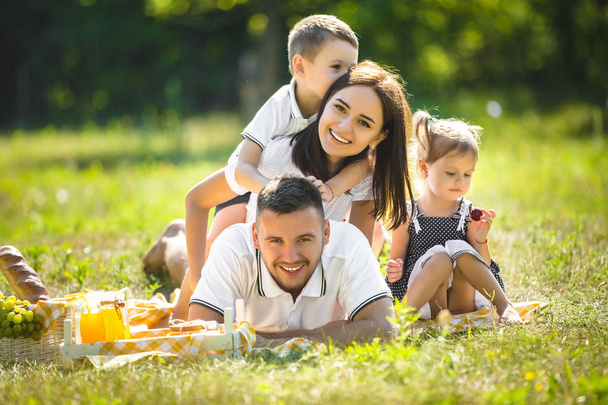 fröhliche Familie beim Picknick. Eltern essen mit ihren Kindern im Freien. - Foto, Bild