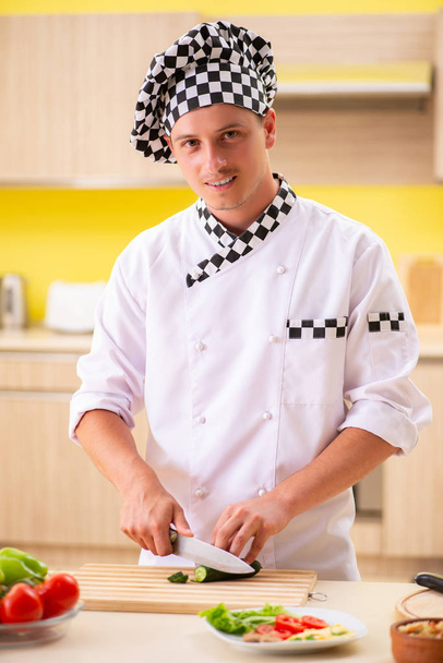 młody profesjonalny kucharz przygotowanie sałatki w kuchni - Zdjęcie, obraz