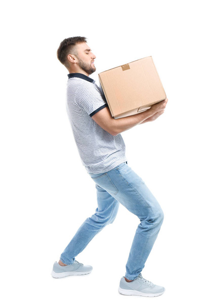 Full length portrait of young man carrying carton box on white background. Posture concept - Foto, Imagen