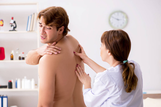 Jovem médico quiroprático massageando paciente masculino
 - Foto, Imagem