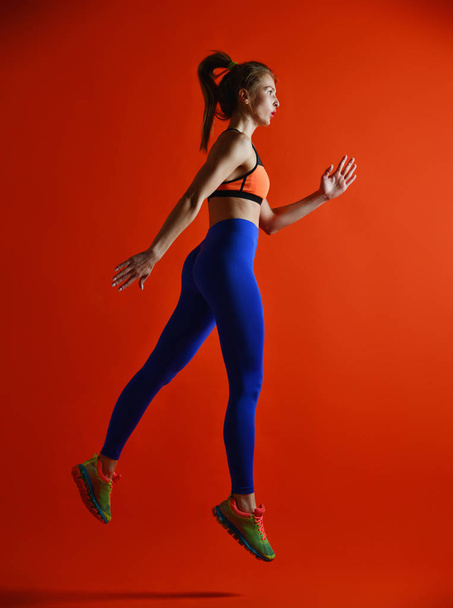 Attractive fitness girl in sportwear jumping - Foto, Imagen