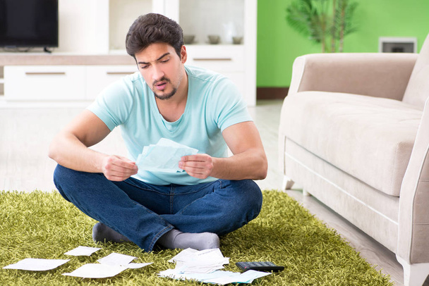 Young man struggling with personal finance and bills - Fotoğraf, Görsel