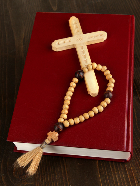 Bible, rosary and cross on wooden table close-up - 写真・画像