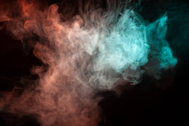 Fumée multicolore provenant d'une bande de couleur verte et rouge de l'étrange forme mystique sur un fond isolé noir. Nuages lumineux sous forme abstraite
. - Photo, image