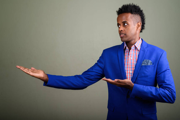 junge gut aussehende afrikanische Geschäftsmann trägt Anzug gegen farbige  - Foto, Bild