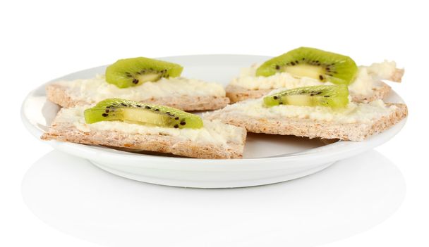 Canapes with cheese and kiwi, on color plate, isolated on white - Photo, image