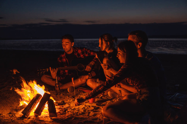 young friends have picnic with bonfire on the beach - Fotoğraf, Görsel
