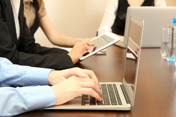 Мужские руки с ноутбуком на фоне офиса
 - Фото, изображение