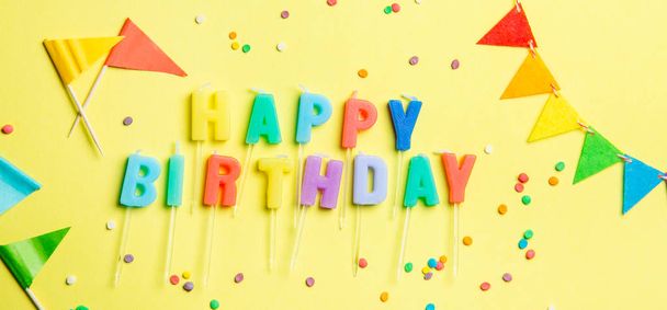 Birthday concept - candles with letters happy birthday and confetti - Foto, imagen