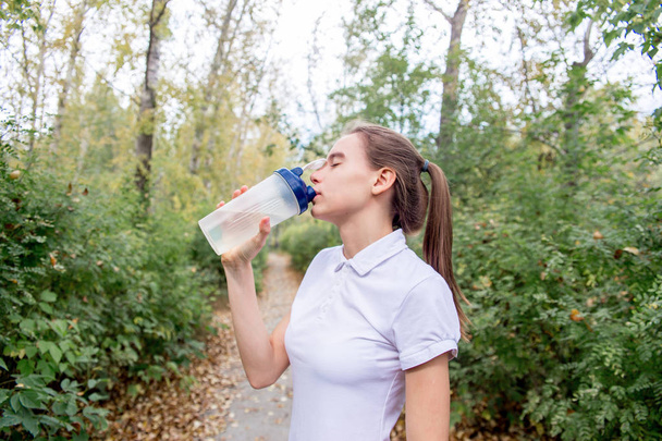 a portrait of a sporty fit girl jogging at park and doing exercises - Fotografie, Obrázek