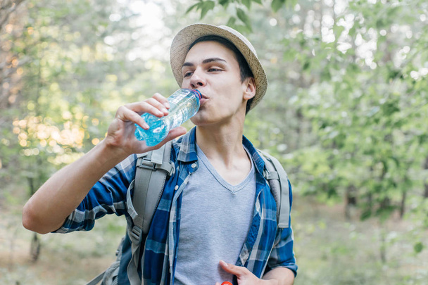Wanderer macht Pause und trinkt Wasser aus Flasche - Foto, Bild