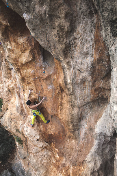 男は、岩を登っていきます。自然の中を登る。フィットネス アウトドア。アクティブなライフ スタイル。極端なスポーツ。自然の救済で選手の列車. - 写真・画像
