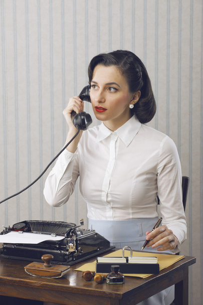 Woman talking on phone at desk - Foto, imagen