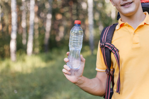 Hiker tourist guy is drinking water from a bottle - Foto, Bild