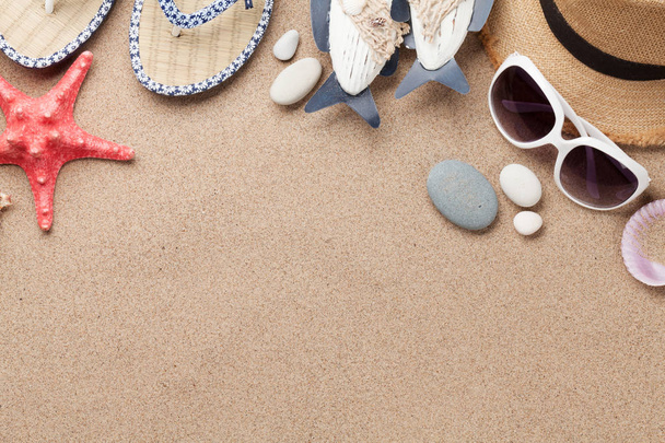 Travel vacation background concept with sunglasses, beach hat and fish decor on sand backdrop. Top view with copy space. Flat lay - Photo, Image