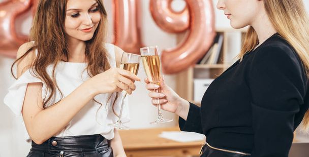 Grupo de mujeres de negocios jóvenes bebiendo champán en la oficina
. - Foto, Imagen