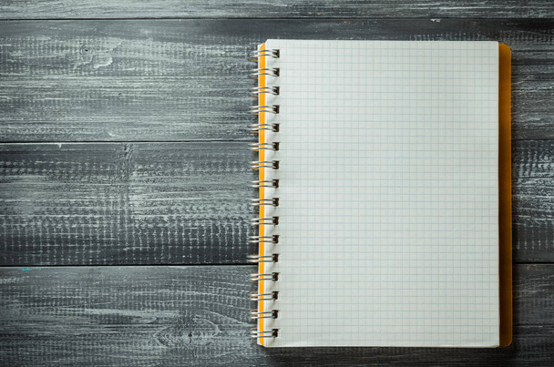 checked notebook on wooden background - Foto, imagen