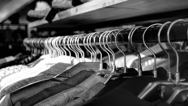 Black and white photo. Clothes on hangers in the store, sales - Photo, Image
