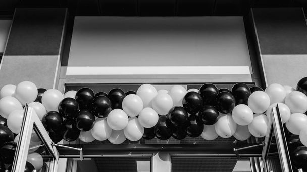 Black and white photo. Many balloons at opening of supermarket - Photo, Image