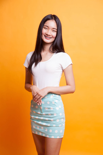 Portrait of beautiful young Asian woman on bright yellow background - Foto, immagini