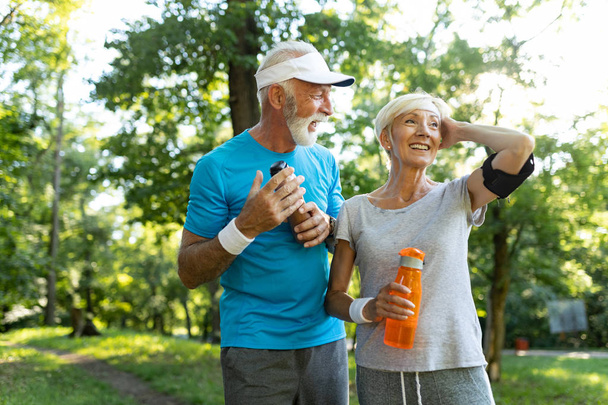 Senior couple jogging and running outdoors in nature - Fotoğraf, Görsel