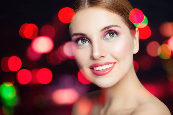 Young fashion woman with makeup smiling on colorful bokeh glitter background - Photo, Image