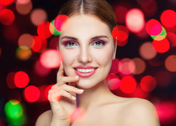 Perfect female face closeup. Young smiling woman with makeup on party glitter background - Photo, Image
