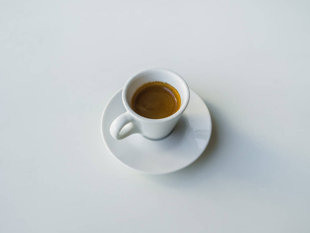 A Cup of strong black coffee on a white table. - Fotó, kép