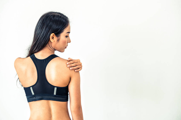 Sporty woman touching shoulder in fitness gym. Healthy lifestyle concept. - Zdjęcie, obraz