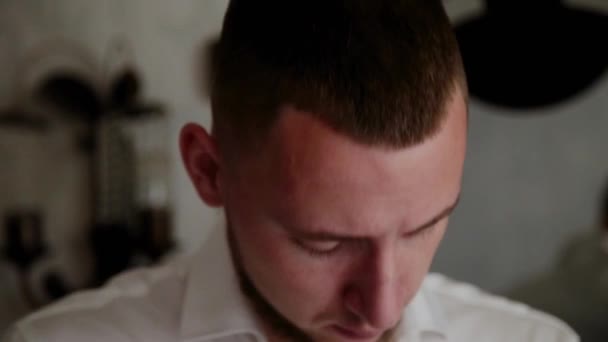 Young man puts cufflinks on a white shirt. - Materiał filmowy, wideo