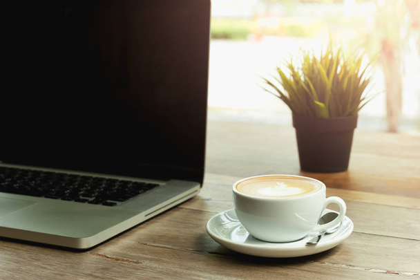 Tasse à café avec ordinateur portable sur table en bois et lumière du matin
 - Photo, image